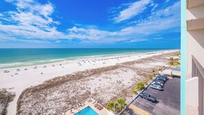 A beach view with a parking lot and a pool area.