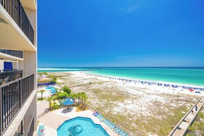 A resort with a pool, beach, and ocean view.