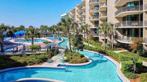 A resort with a large swimming pool, palm trees, and a multi-story building with balconies. - Spend Vacation on the Bay!! 3 BR 3 BA ~ LOW FLOOR! (Orange Beach)