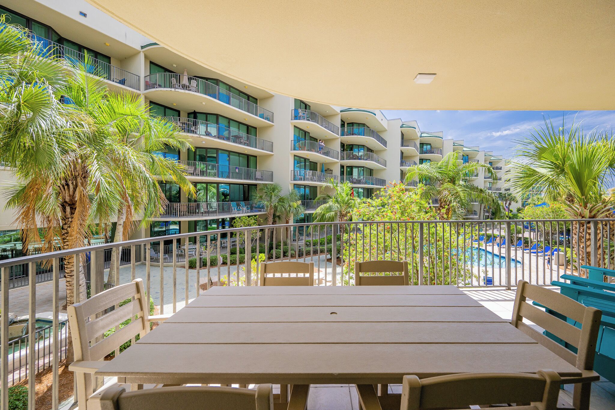 Un balcón de hotel con varios niveles, mobiliario exterior y zona de piscina.