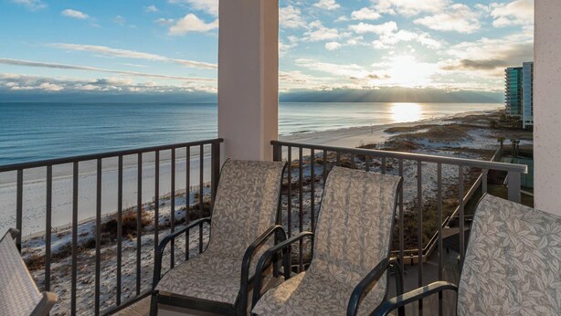 A balcony with two chairs facing a beach and ocean view. - 6th FLOOR! XTRA BATH! 3 BR 3 BA ~ Phoenix X (Orange Beach)
