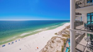 A beach view from a hotel balcony with a pool and outdoor seating. - The Oasis at Orange Beach, formerly known as Phoenix West II, Unit 1710 (Orange Beach)