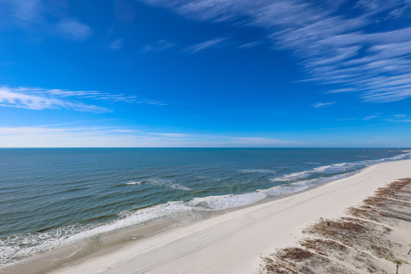 A beach with a clear sky and calm sea.