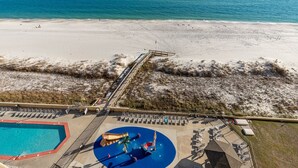 Luchtbeeld van een strandresort met een zwembad, een glijbaan en een strandgedeelte.