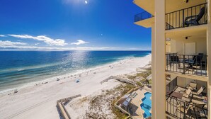 A beachfront hotel with a pool, multiple balconies, and a view of the beach and ocean.