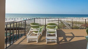 Un balcon avec deux fauteuils Adirondack verts et un espace piscine.