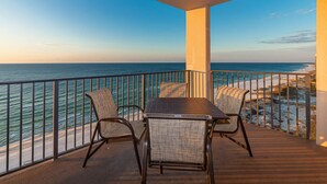 A balcony with a table and chairs overlooking the ocean. - 2 BR Beachfront Escape You’ll Never Forget! Phoenix X 1215 (Orange Beach)