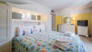 A bedroom with a bed, a television, a dresser, and a window.
