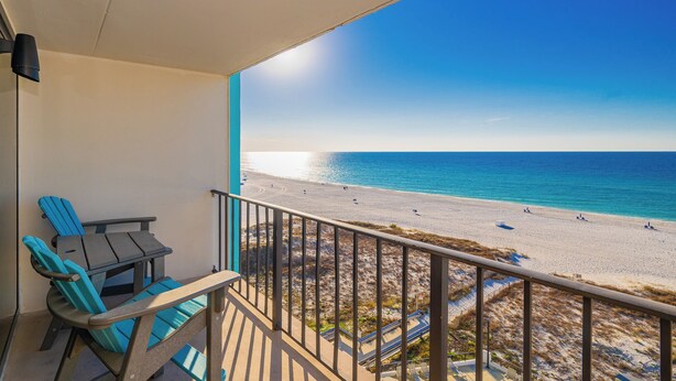A balcony with a view of a beach and ocean.