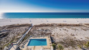 A beach view with a pool area, including lounge chairs and a small pool.