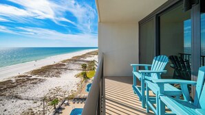 Un balcon avec vue sur une plage et l’océan.