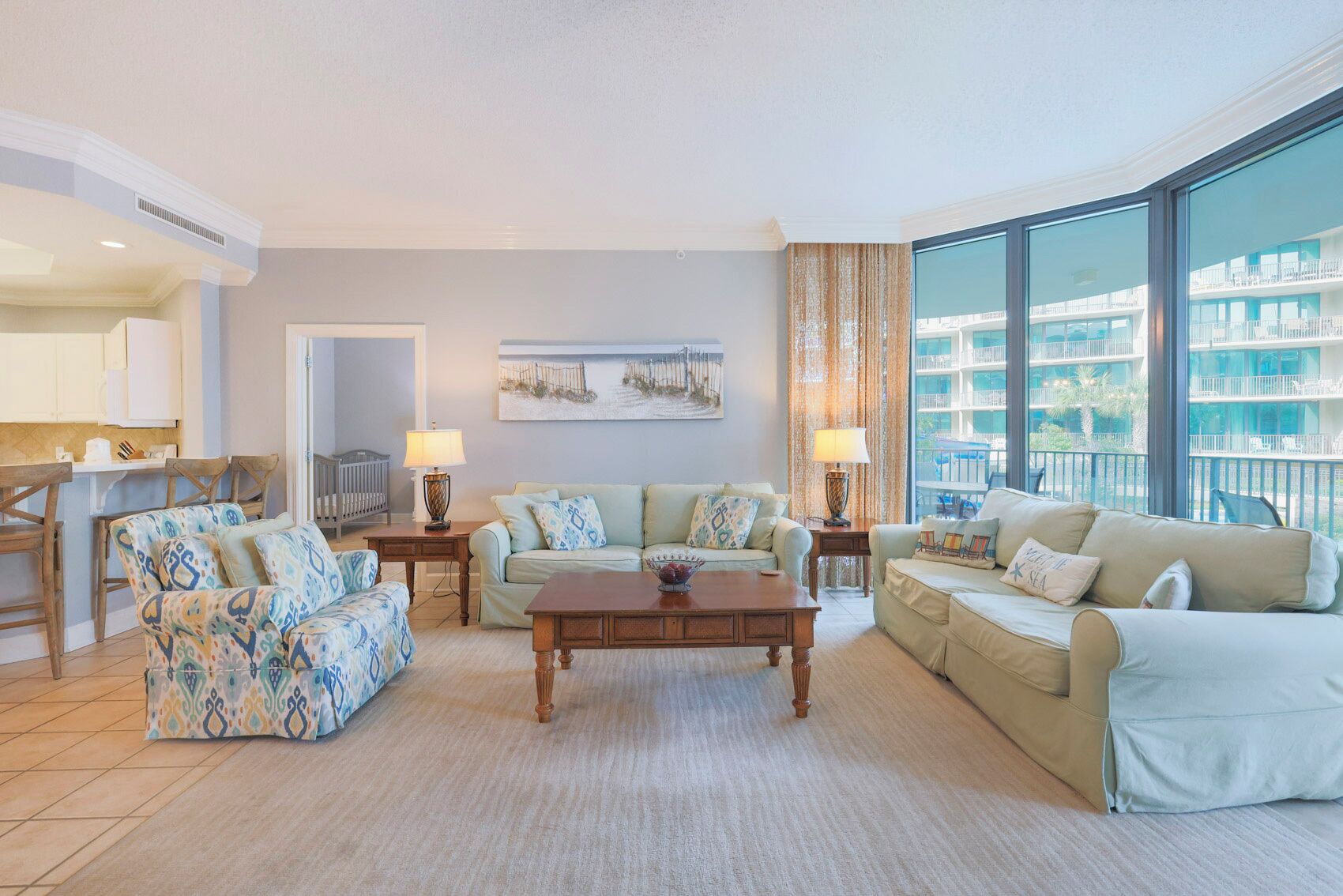 A spacious living room with a large window, a dining area, and a kitchen.