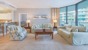 A spacious living room with a large window, a dining area, and a kitchen. - The Gulf’s Favorite Place to Stay Phoenix On The Bay 1111 (Orange Beach)