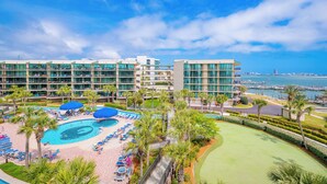 A hotel with a pool, lounge chairs, palm trees, and a view of the marina. - BRING the BOAT!! 3 BR 3 BA…Phoenix On The Bay!! (Orange Beach)