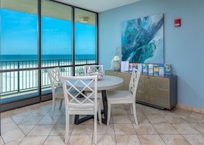 Enjoy ocean views from the large window in this stylish room, featuring a round table and comfortable seating for four.