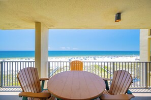 A covered outdoor seating area with a view of a beach. - Phoenix IV - 4th Floor - 3 Bedroom (Orange Beach)