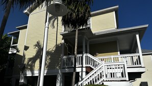 Un edificio de dos pisos con un balcón y una escalera.