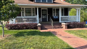 A two-story house with a porch, number 835, and a brick chimney. - Haywood House: West Asheville's Newly Restored And Most Walkable Rental! (Asheville)