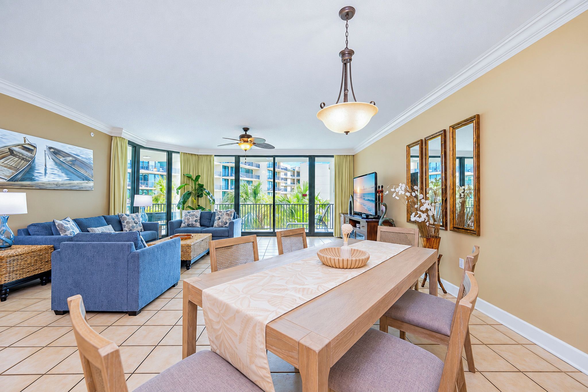 Ein geräumiges Wohnzimmer mit Essbereich, großen Fenstern und einem Deckenventilator.