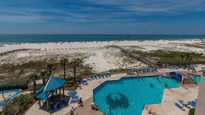 A beach resort with a large swimming pool, sun loungers, and a view of the ocean. - 2 BR @ Phoenix East - 4th Floor (Orange Beach)