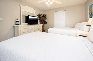 A bedroom with a large bed, a dresser, a television, and a window with blinds.