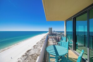 A balcony with a view of a beach and ocean.