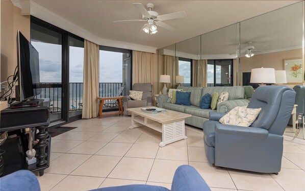 Relax in this stylish living room with a sofa set, armchair, and flat-screen TV, offering a view of the ocean.
