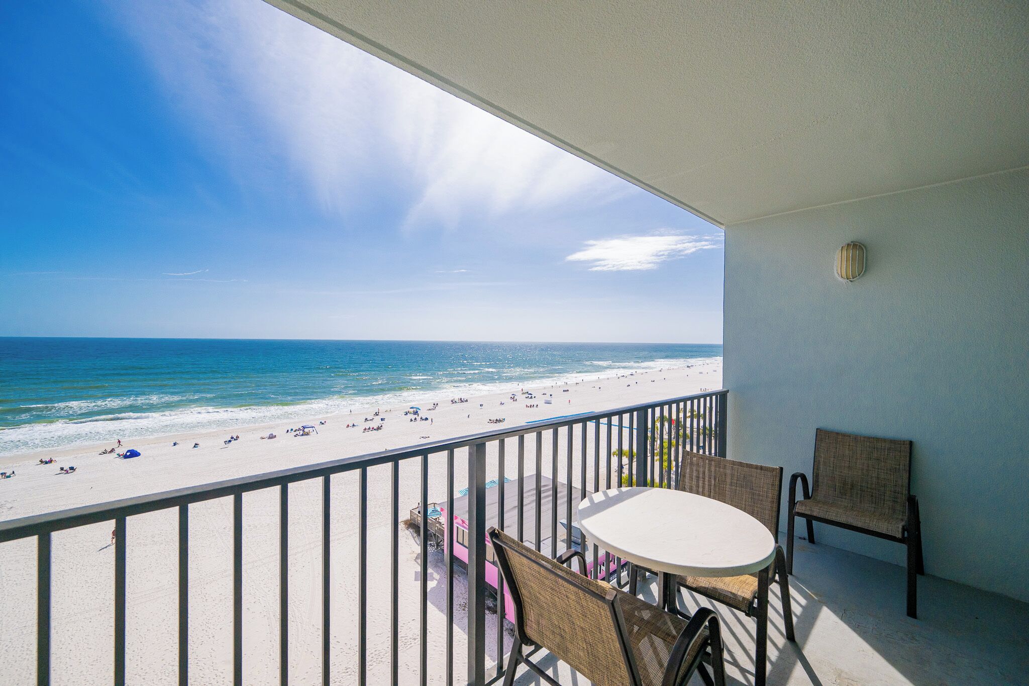 Un balcon avec vue sur une plage et l’océan.