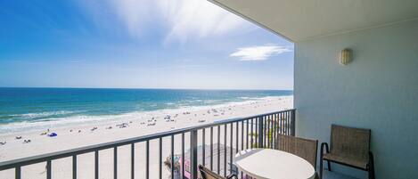 Un balcon avec vue sur une plage et l’océan.