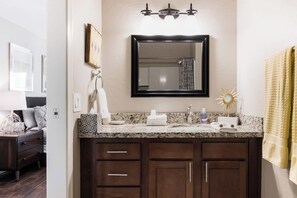 A bathroom with a granite countertop, a black-framed mirror, and dark wooden cabinets. - Architect-Designed Retreat with a BBQ Patio and Pool (Mesa)