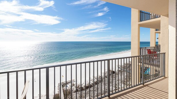 A balcony with a view of a beach and ocean.