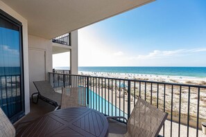 Een balkon met uitzicht op strand en zee.