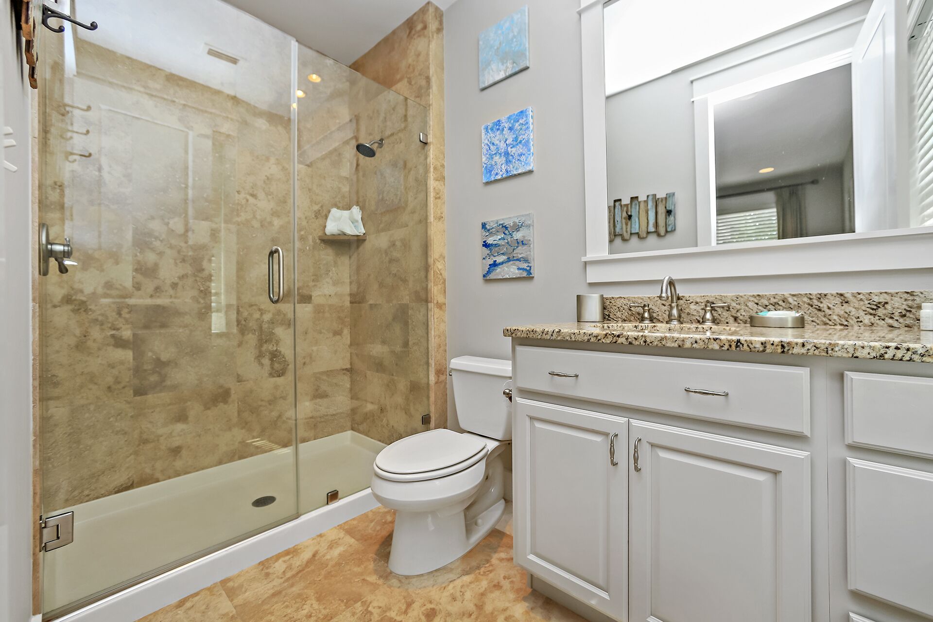 A modern bathroom with a glass-enclosed shower, a toilet, and a vanity with a sink.