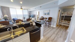 Une cuisine moderne équipée d’un évier, d’un lave-vaisselle et d’un coin repas avec une table et des chaises.