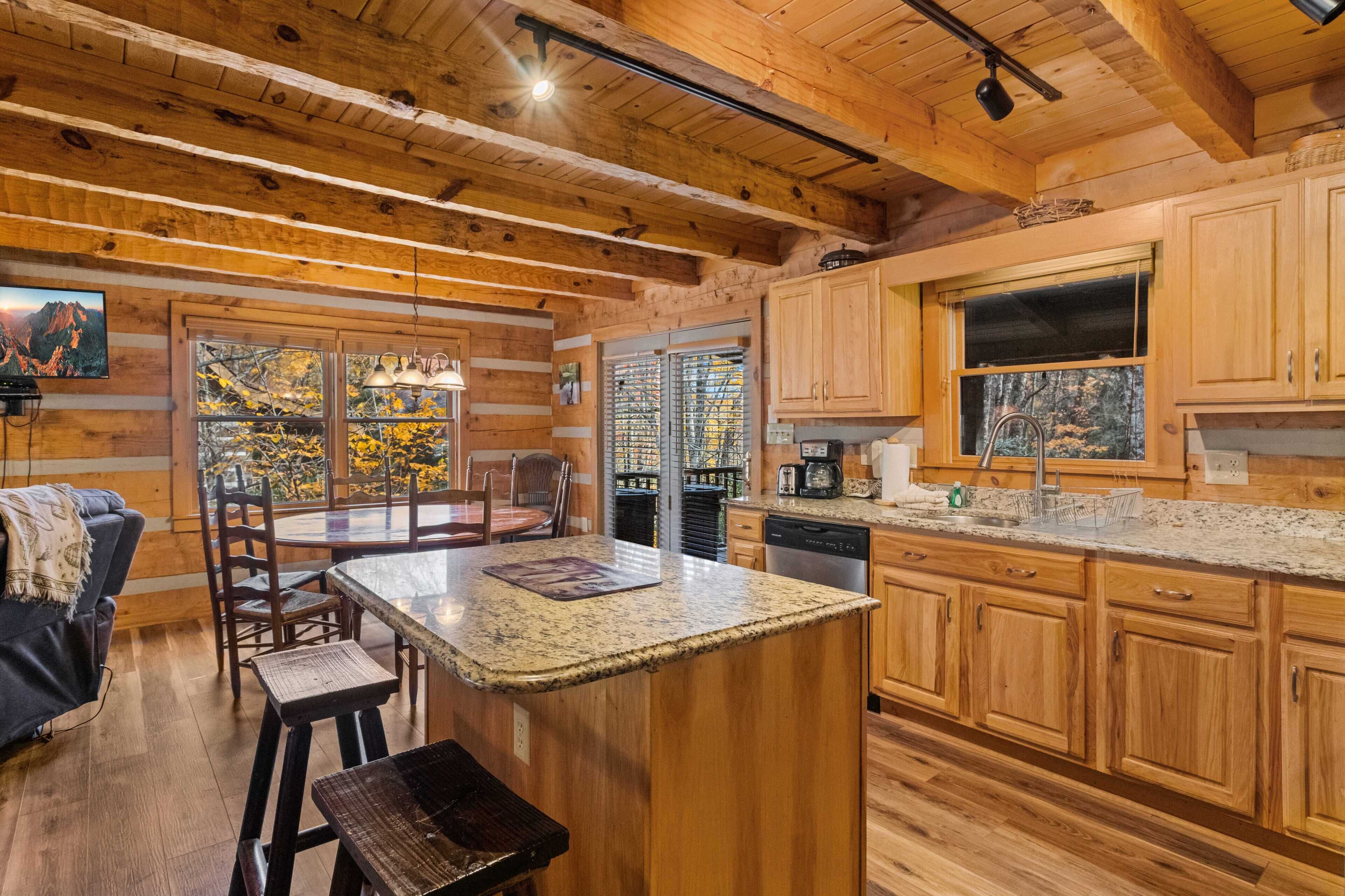 A rustic kitchen with wooden cabinets, a granite countertop, and a dining area with a table and chairs.