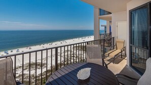A balcony with a view of a beach and ocean.
