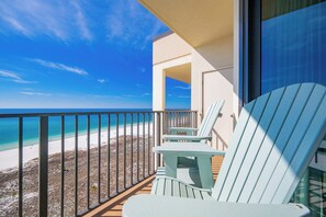 Uma varanda com vista para a praia e o oceano.