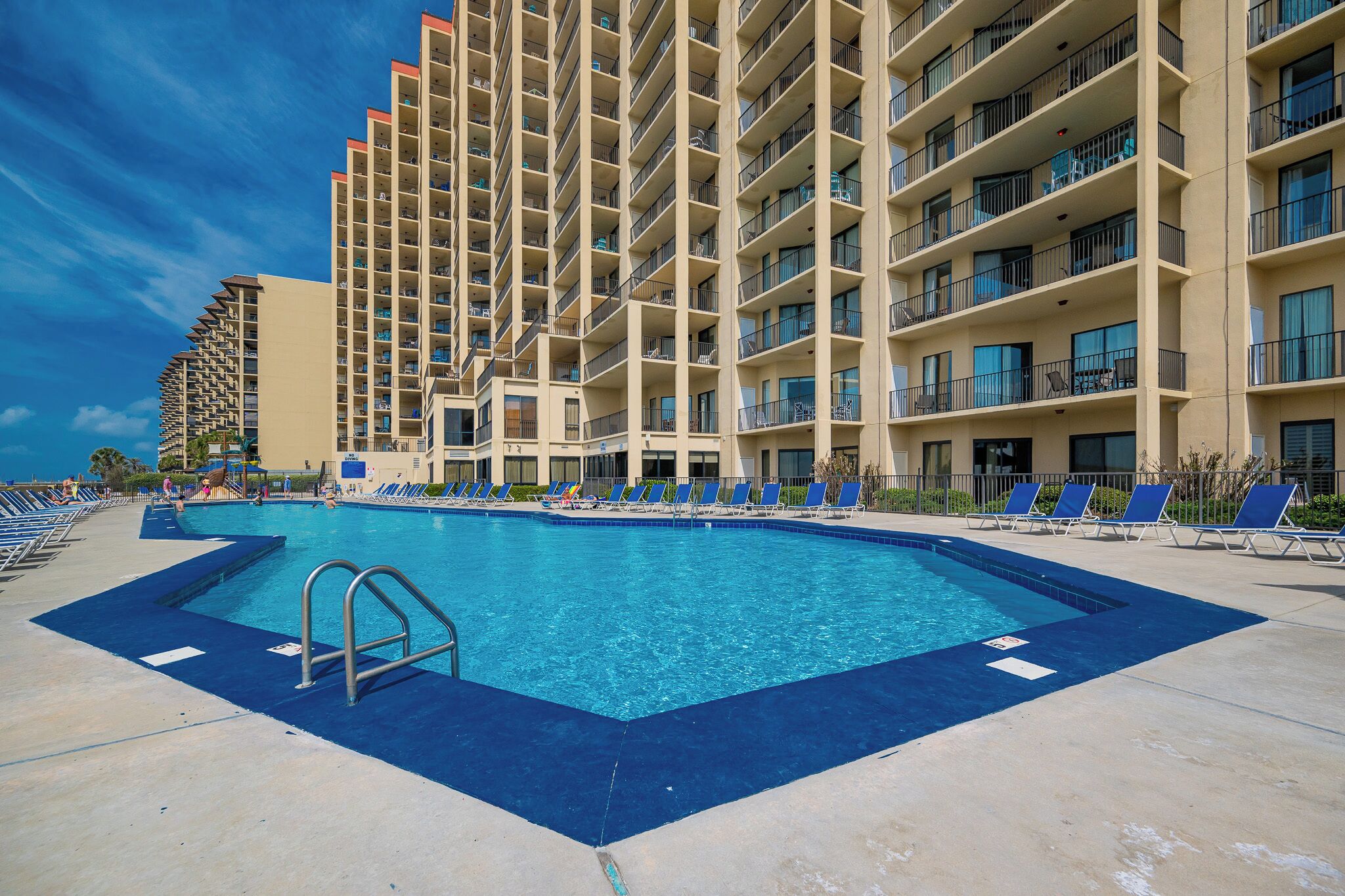 Relax by the sparkling pool with lounge chairs and easy access to beachfront fun at this inviting rental property