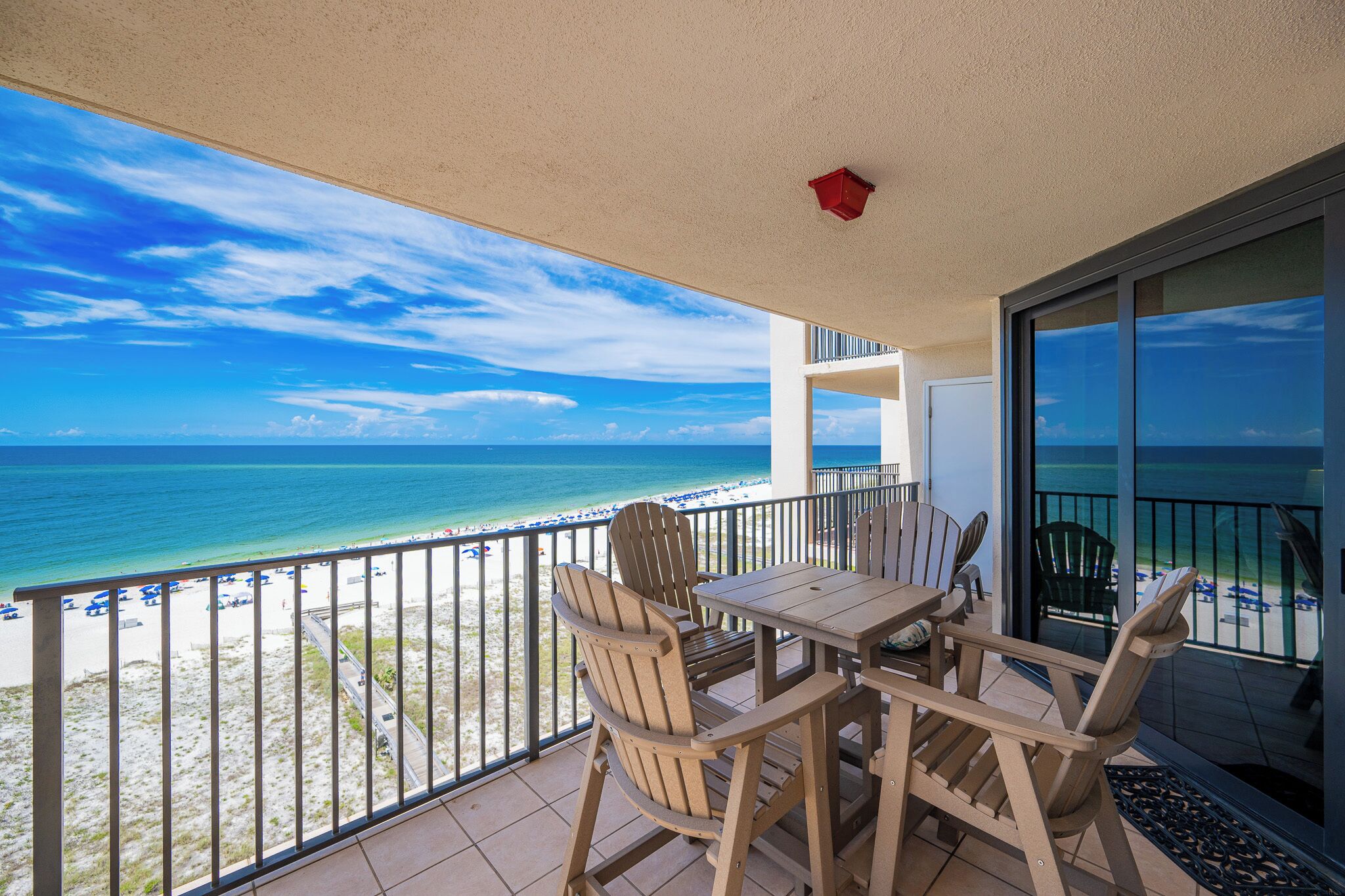 A balcony with a view of the beach and ocean.