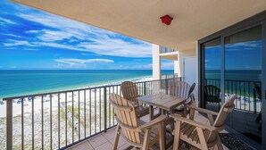Een balkon met uitzicht op strand en zee.