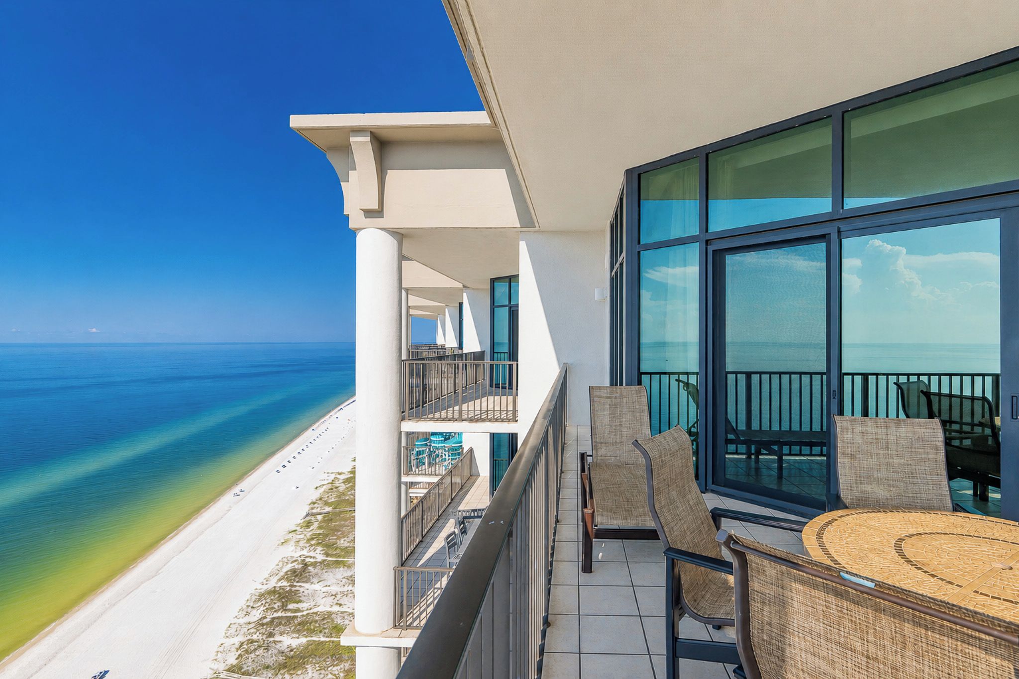 A balcony with a view of a beach and the ocean.