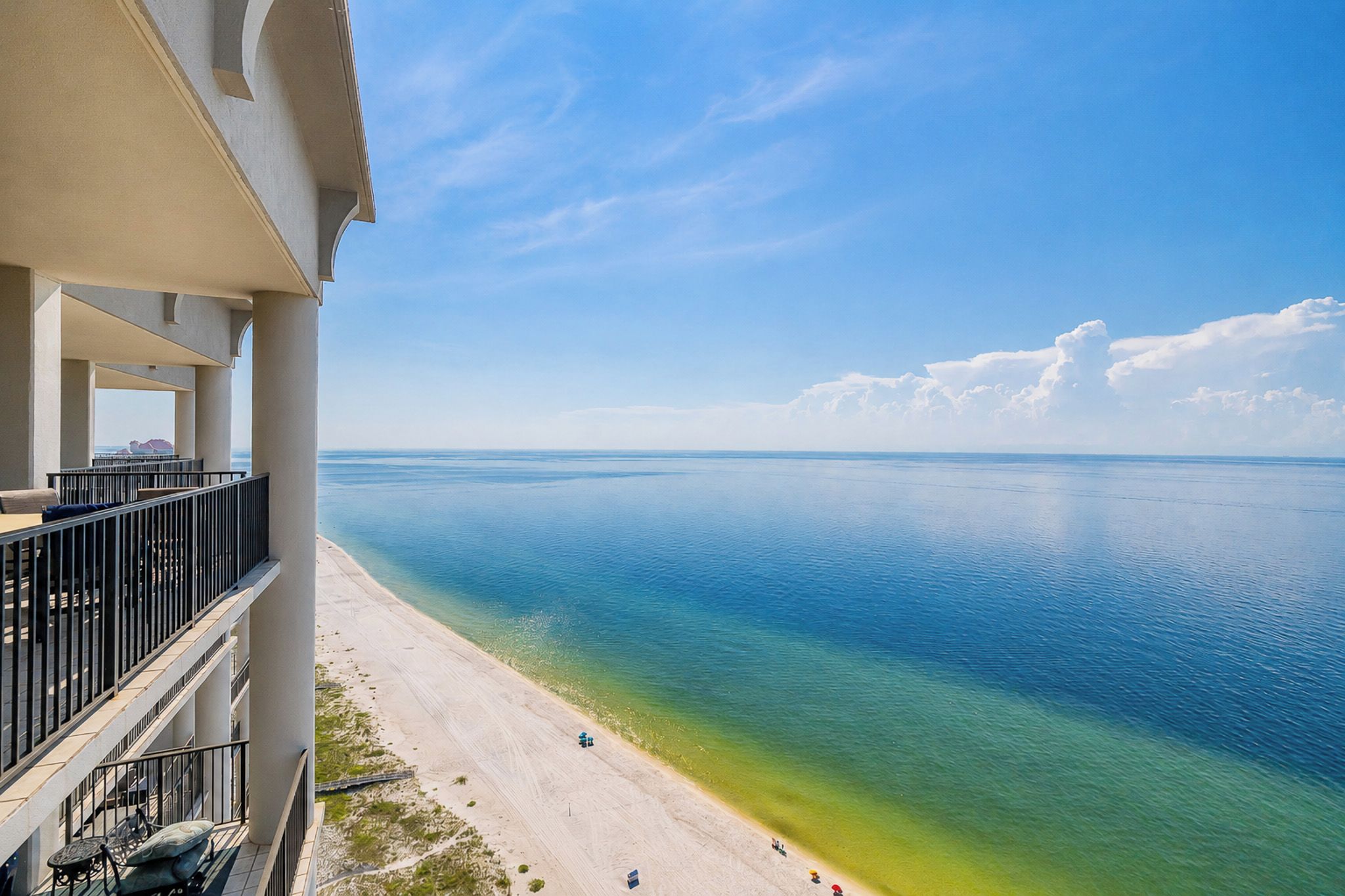 Een balkon met uitzicht op een strand en de oceaan.