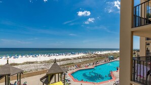 A beach view with a swimming pool and beach umbrellas. - Second Floor Beach Front Balcony! 1BR 1BA @ Phoenix V (Orange Beach)