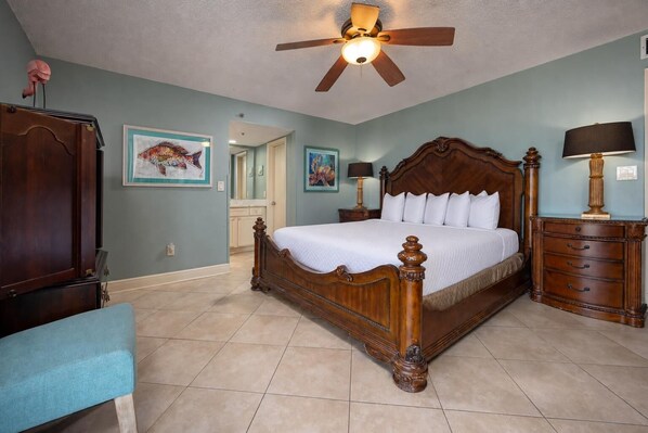 A bedroom with a wooden bed, a ceiling fan, a nightstand, and a dresser. - Beachfront 3BR Condo - Phoenix I 1038 (Orange Beach)