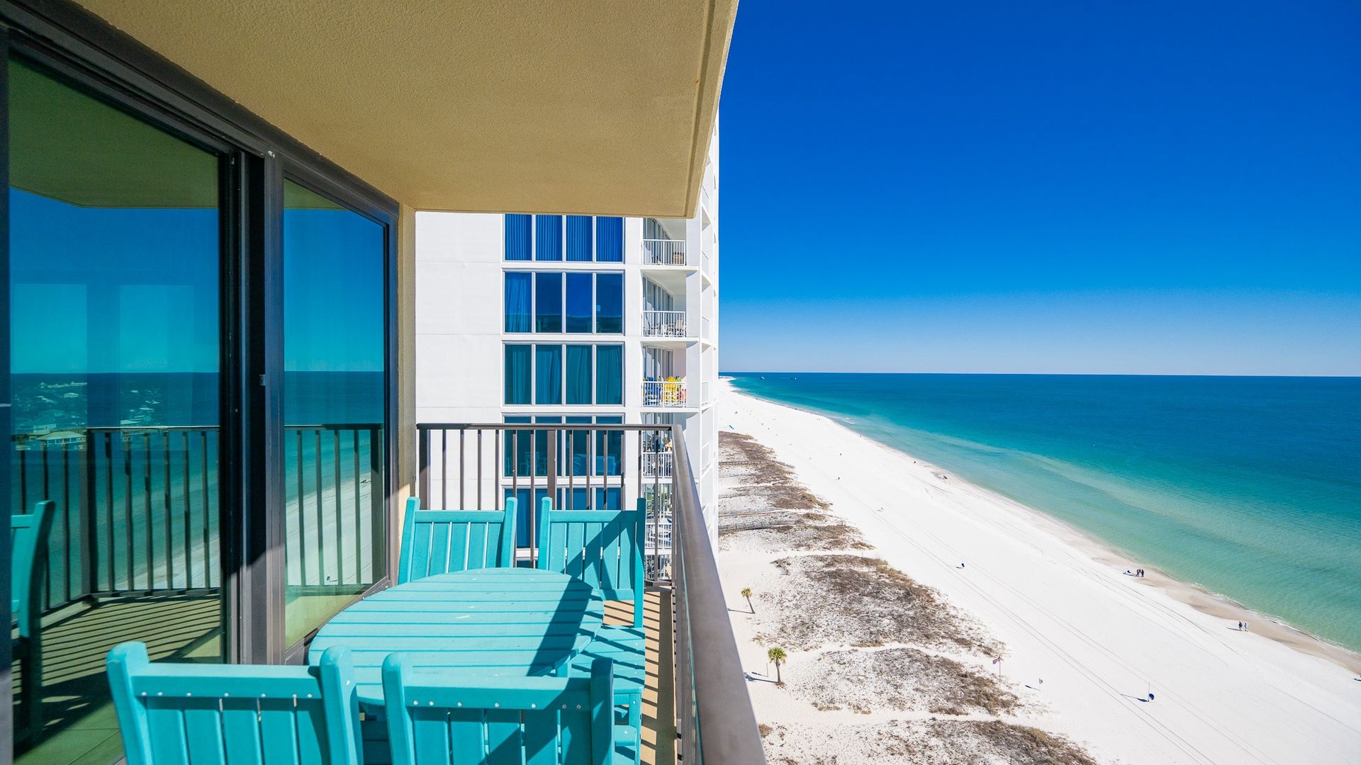 A balcony with a view of a beach and ocean.