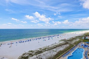 A beach with umbrellas and a swimming pool.