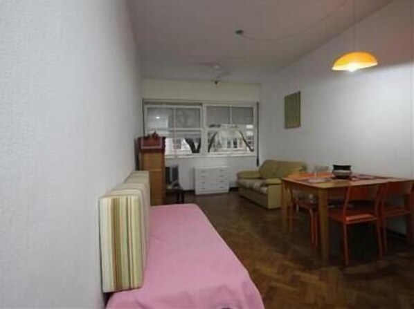 A compact living space with a kitchenette, a dining area with a table and chairs, and a window providing natural light.