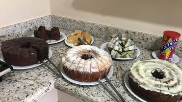 Uma bancada de cozinha com vários bolos e uma lata de Nescafé Zest.