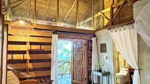 A room with a bed, wooden furniture, a ceiling fan, and a view of the outdoors. - Isleta El Espino Ecolodge (Granada)