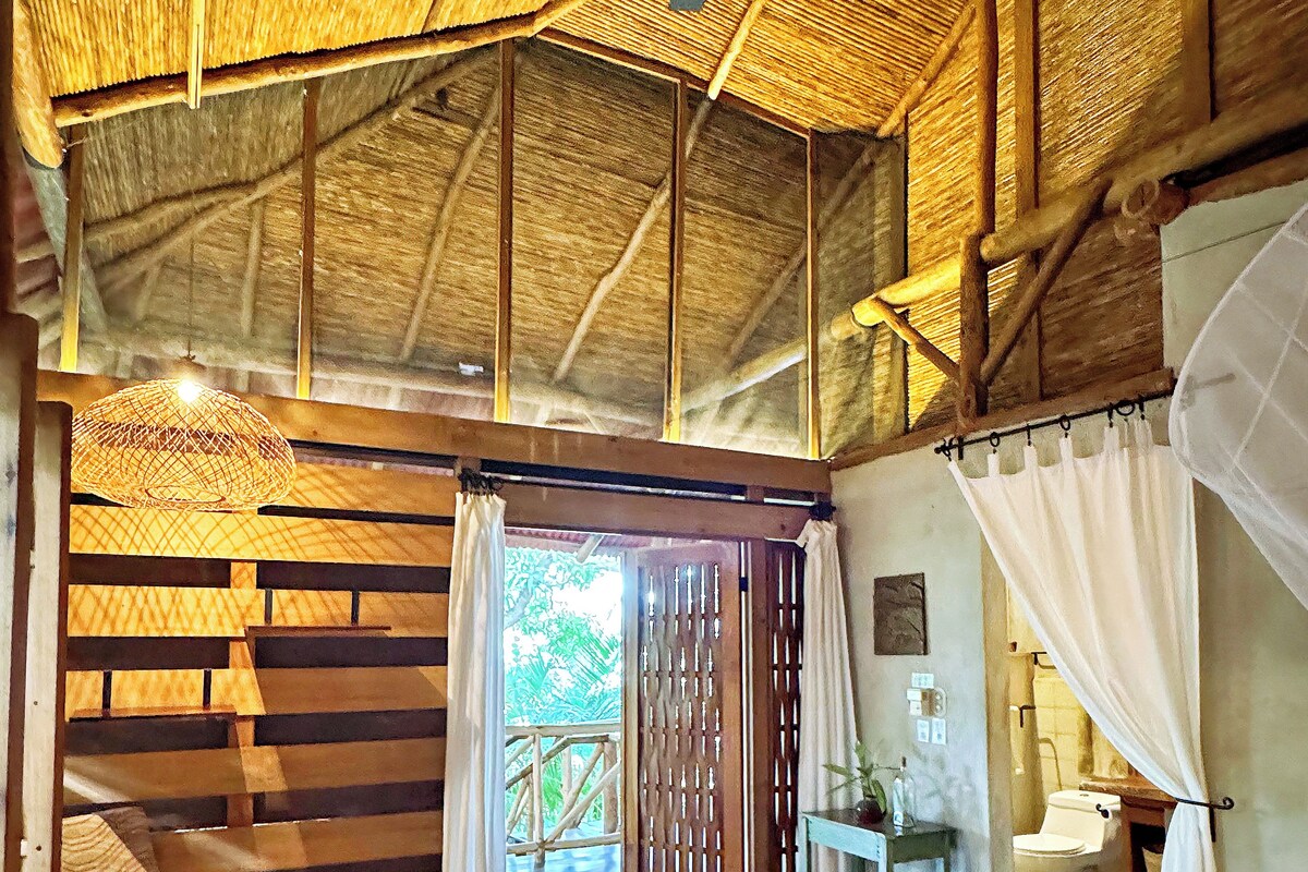 A room with a bed, wooden furniture, a ceiling fan, and a view of the outdoors.